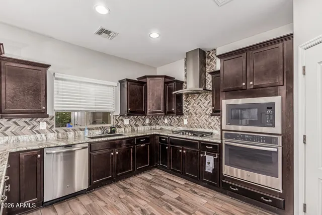 a kitchen with stainless steel appliances granite countertop a sink and stove top oven