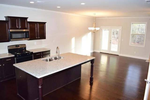 a kitchen with a sink a oven a refrigerator and wooden floor