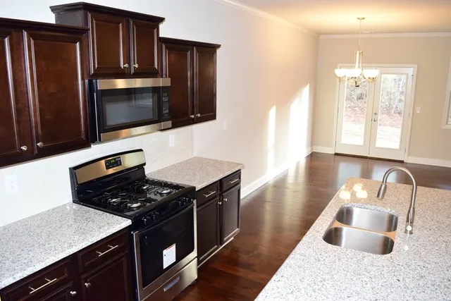 a kitchen with granite countertop stainless steel appliances and wooden cabinets