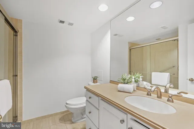 a bathroom with a granite countertop sink toilet and a mirror