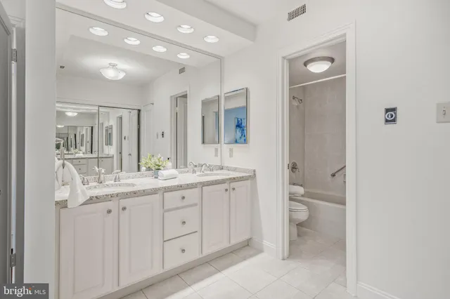 a bathroom with a granite countertop sink a toilet and a mirror