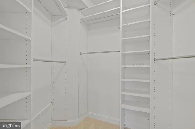 a view of walk in closet with empty racks