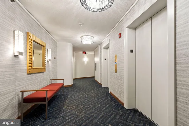 a hallway with a wooden floor and a chair