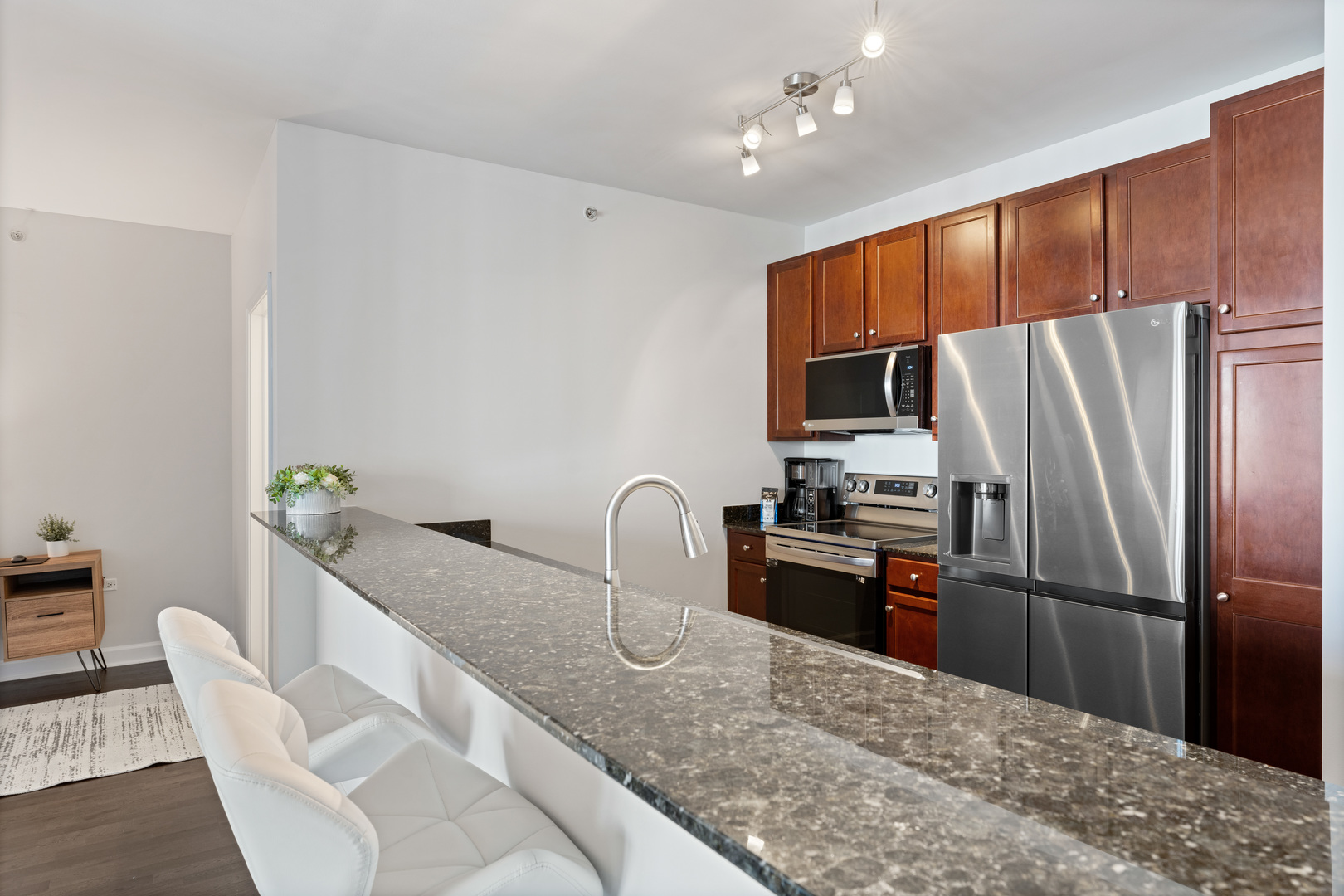 100 East 14th Street, Unit 1203 Chicago, IL 60605 - Photo 12 of 28 a kitchen with granite countertop a refrigerator and a sink