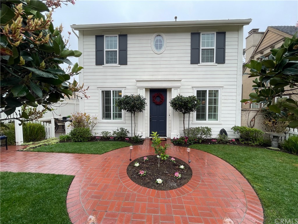 a front view of a house with a garden and plants