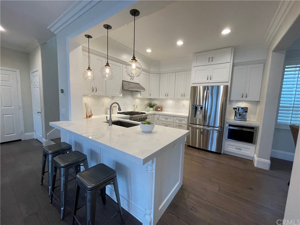 21 Kelfield Drive Ladera Ranch, CA 92694 - Photo 3 of 18 a kitchen with stainless steel appliances a table chairs refrigerator and microwave