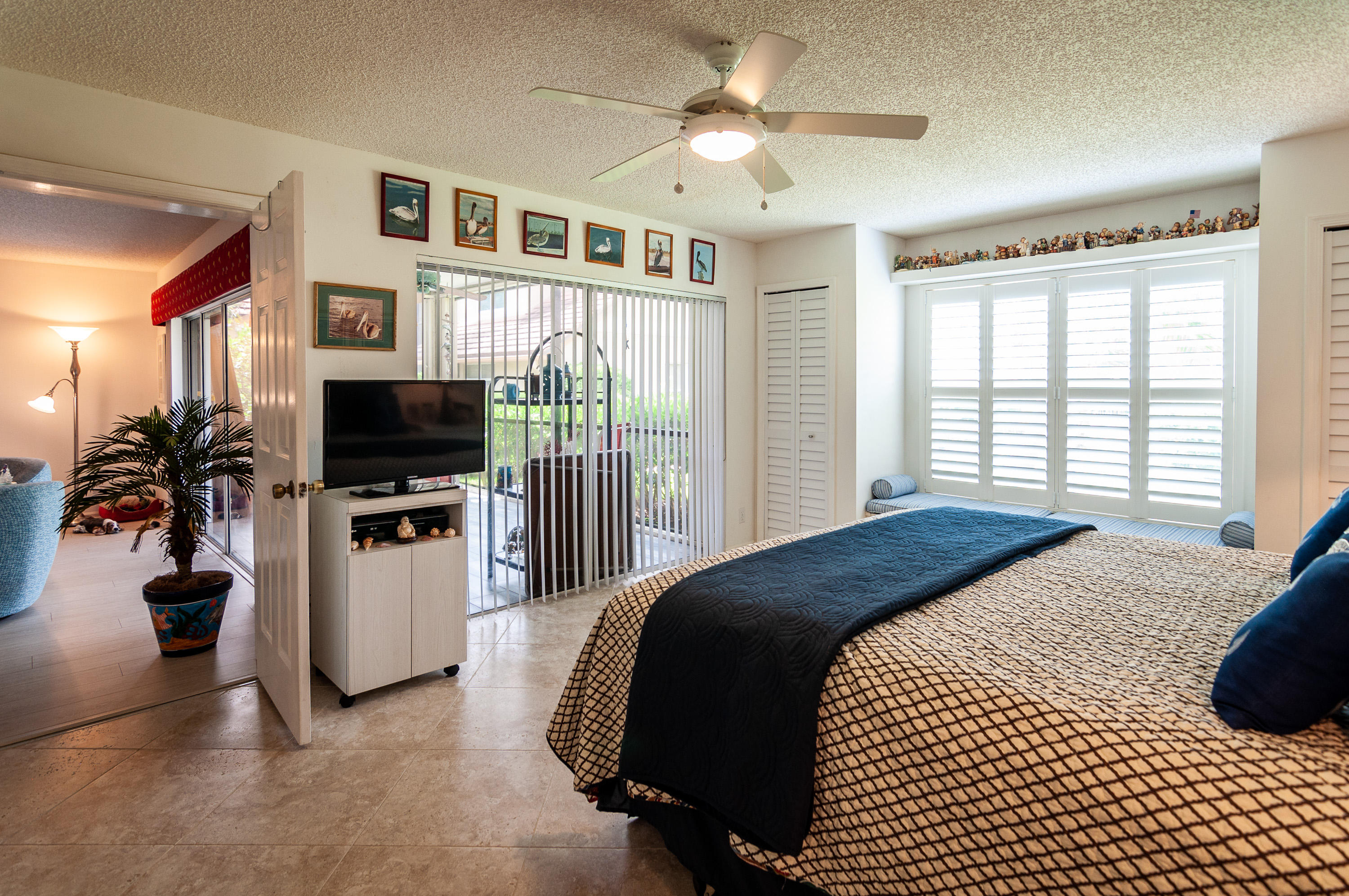 4161 U.S. Highway 1, Unit E2 Jupiter, FL 33477 - Photo 16 of 37 a bedroom with a bed and a flat tv screen on the dresser