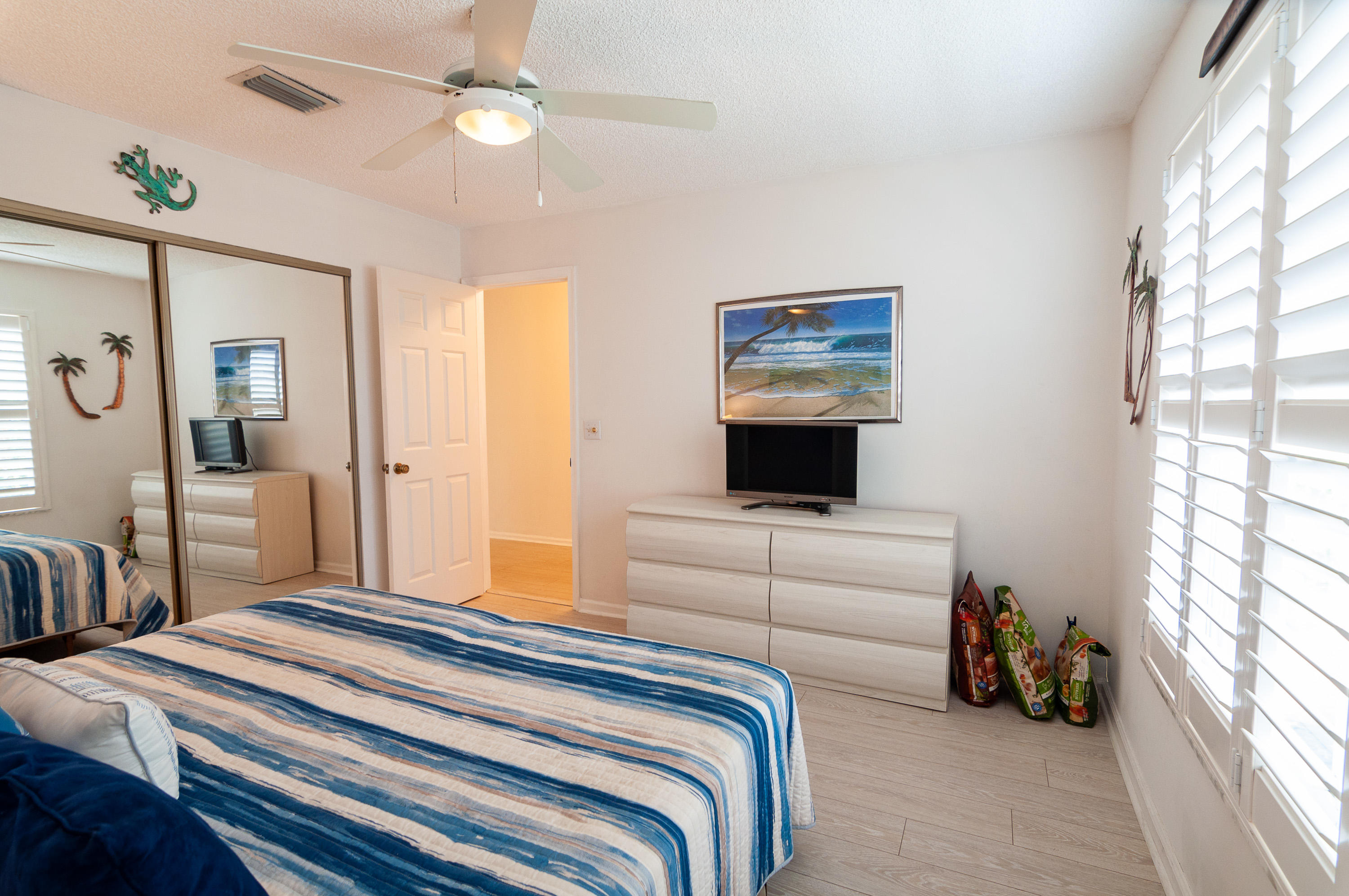 4161 U.S. Highway 1, Unit E2 Jupiter, FL 33477 - Photo 22 of 37 a bedroom with bed and a chandelier
