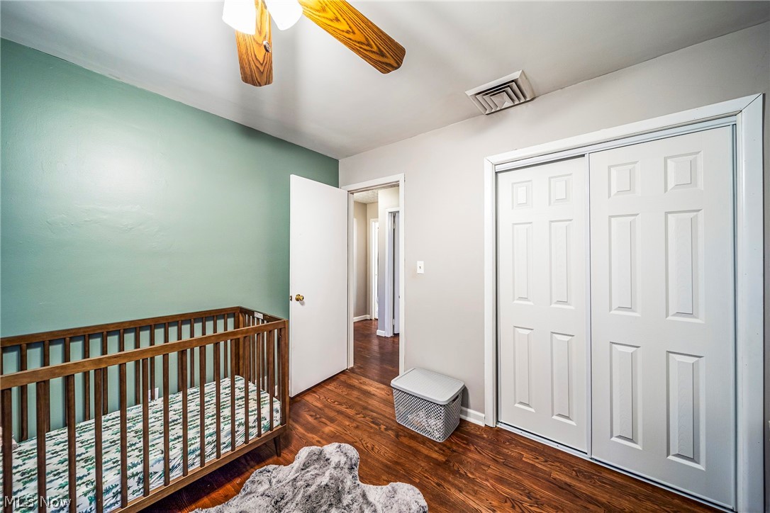 901 Lloyd Road Wickliffe, OH 44092 - Photo 20 of 40 Bedroom featuring a nursery area, dark wood-type flooring, a closet, and ceiling fan