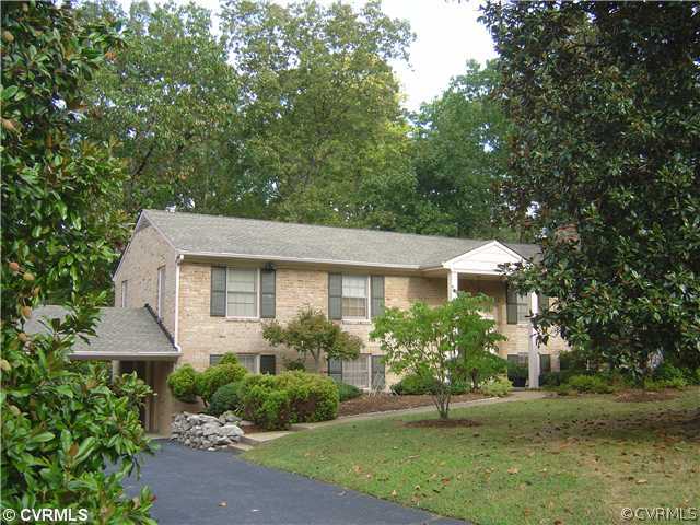 a front view of a house with a yard and trees