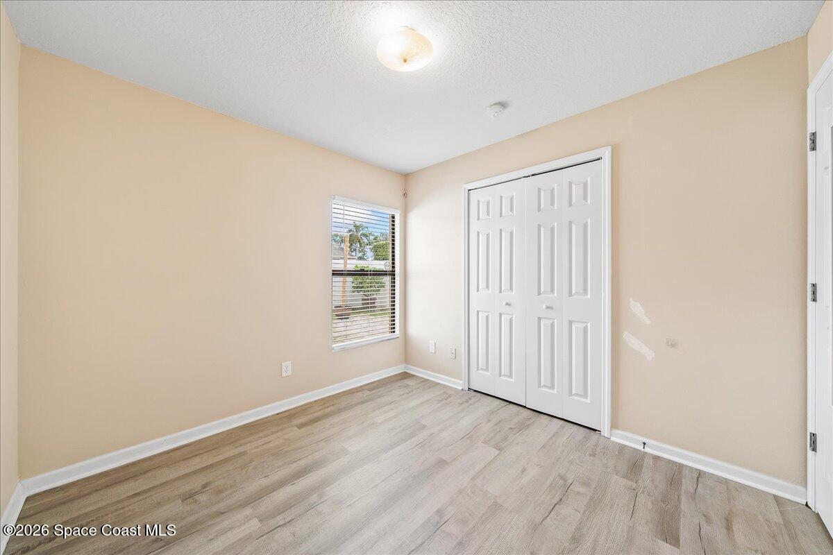 870 Luminary Circle, Unit 103 Melbourne, FL 32901 - Photo 12 of 23 an empty room with wooden floor and windows