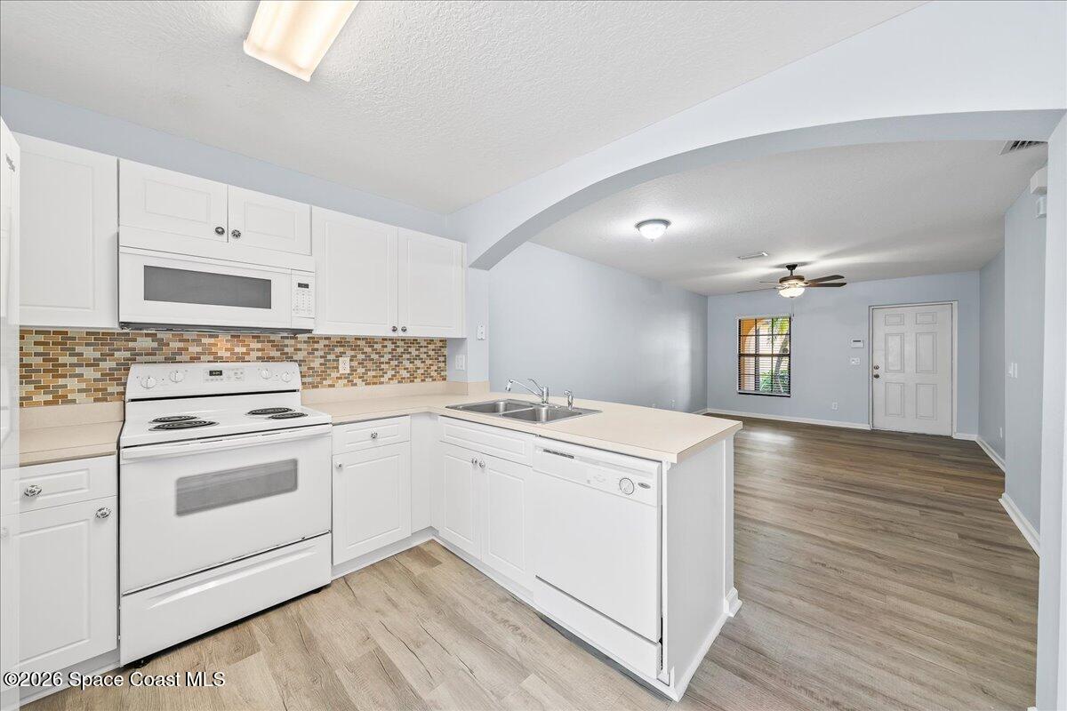 870 Luminary Circle, Unit 103 Melbourne, FL 32901 - Photo 7 of 23 a kitchen with a stove cabinets and wooden floor