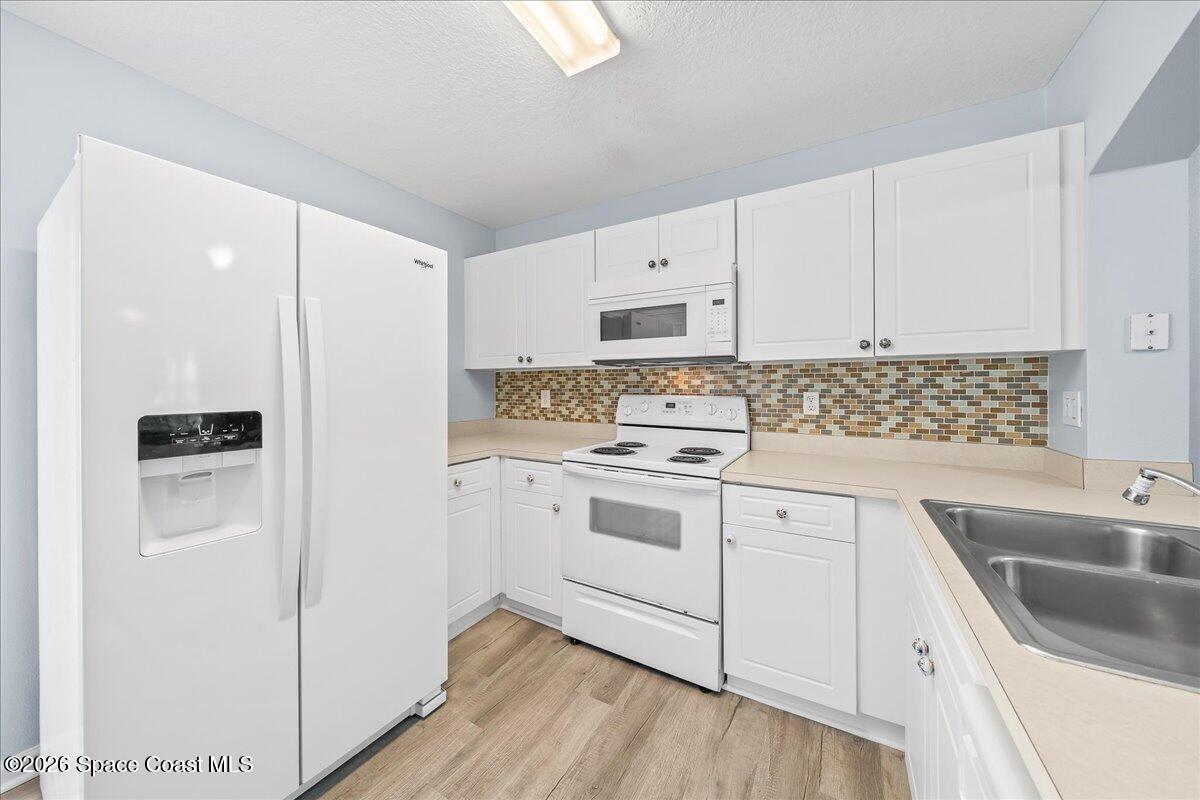 870 Luminary Circle, Unit 103 Melbourne, FL 32901 - Photo 8 of 23 a kitchen with cabinets appliances a sink and a counter space