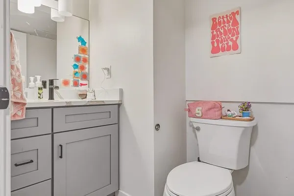 a bathroom with a sink mirror vanity and toilet