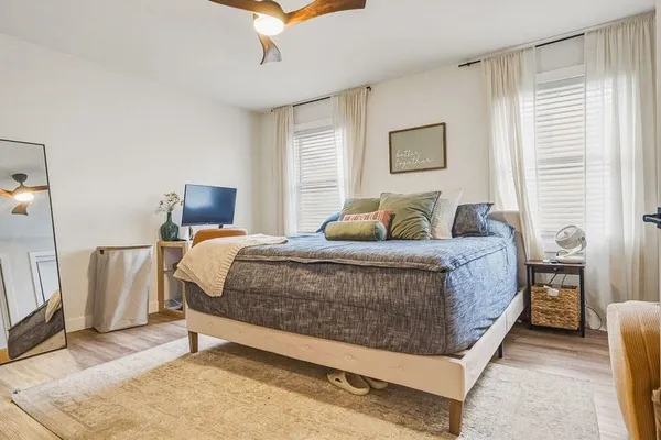 a bedroom with a bed lamp and a window