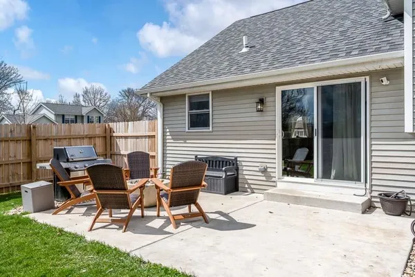 a patio with table and chairs and potted plants