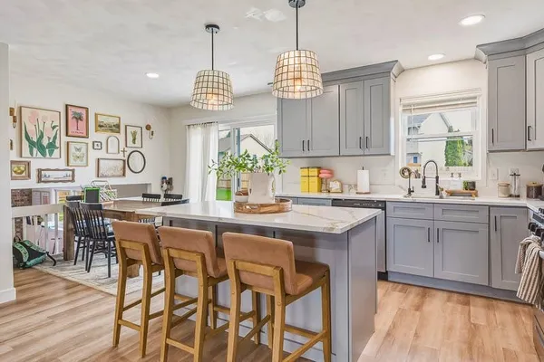 a kitchen with a dining table chairs and cabinets