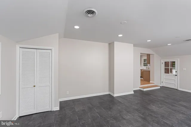 a view of a livingroom with wooden floor and kitchen