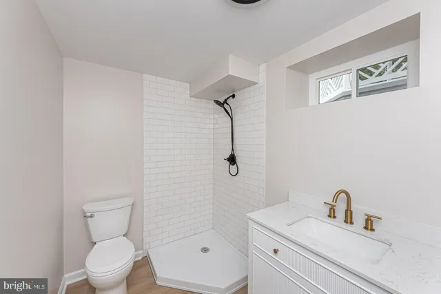 a bathroom with a toilet sink vanity and mirror