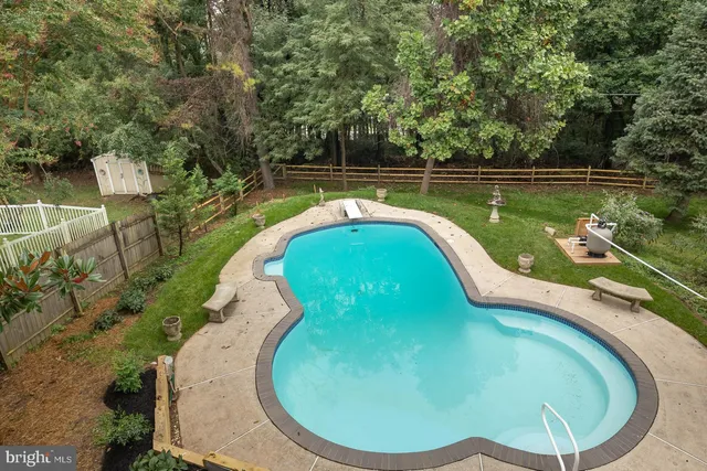 an aerial view of a house with a yard and large trees