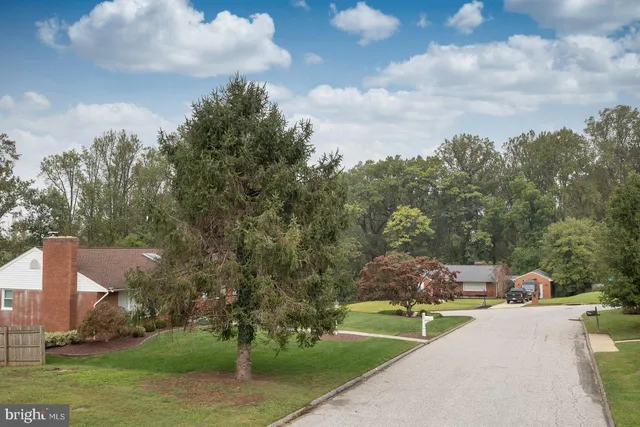 a front view of a house with a yard and trees