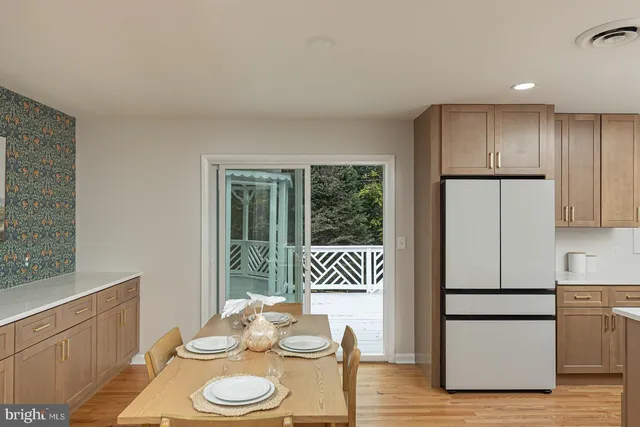a kitchen with a refrigerator and wooden floor