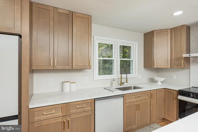 a kitchen with stainless steel appliances granite countertop a sink a stove and cabinets