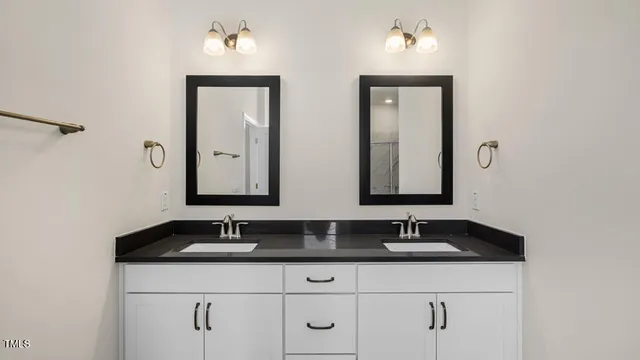 a bathroom with double sink and a mirror