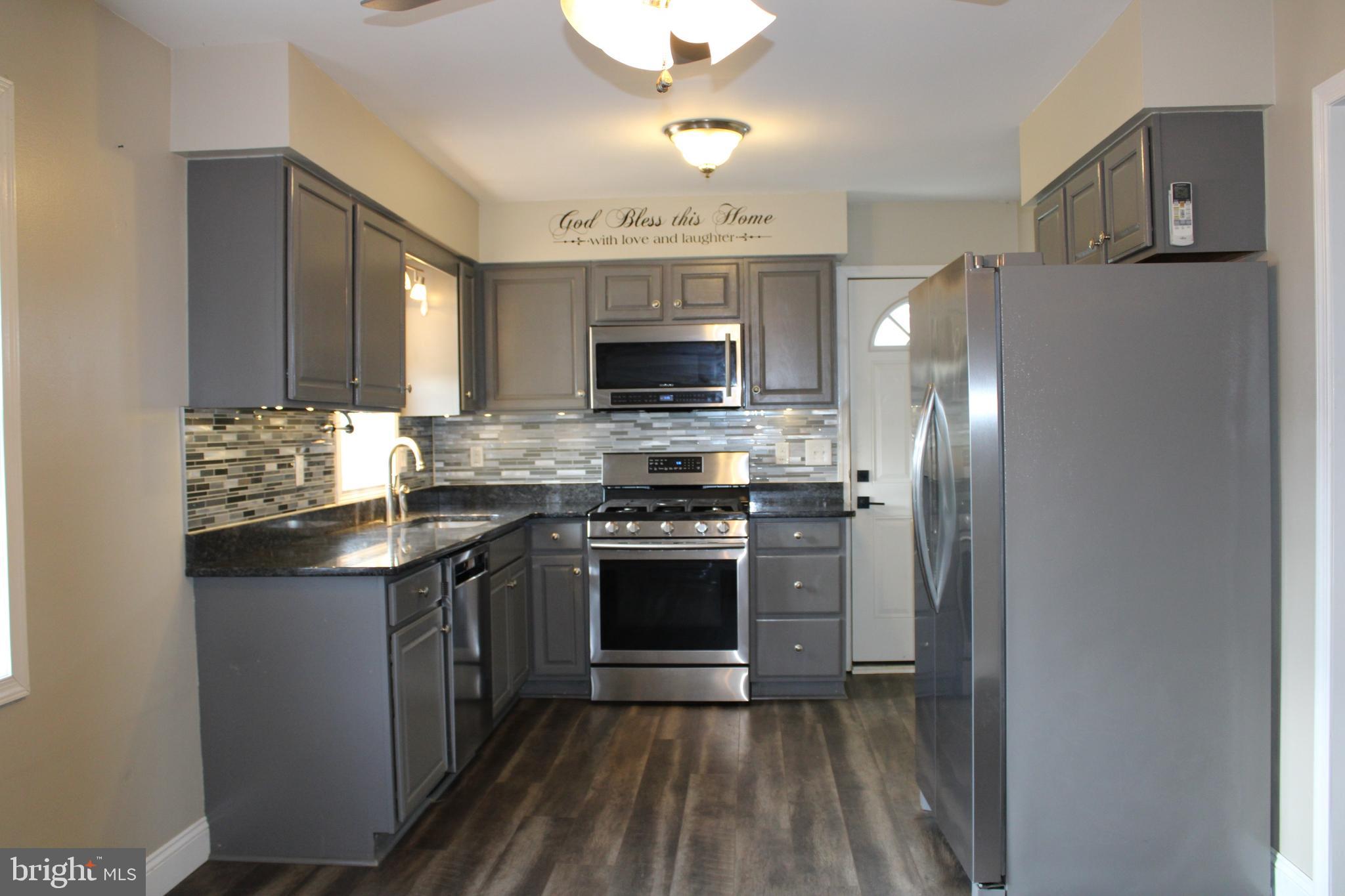 28380 Beaver Dam Branch Road Laurel, DE 19956 - Photo 6 of 22 a kitchen with stainless steel appliances granite countertop a stove refrigerator and a microwave
