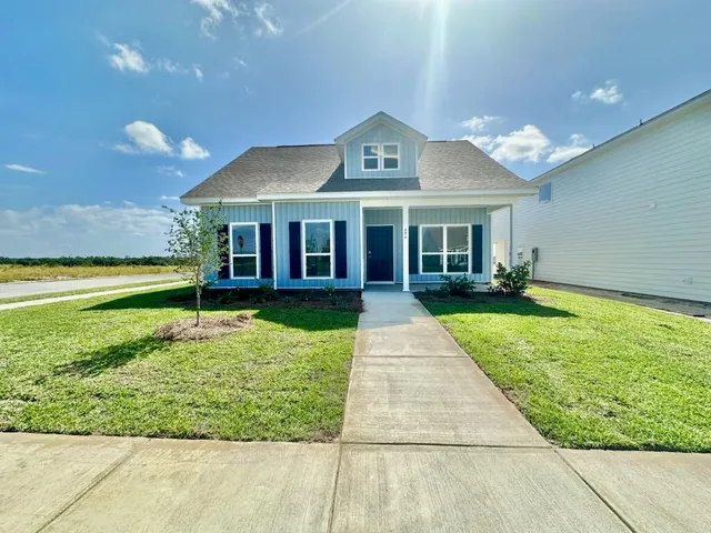 a front view of a house with a yard and potted plants
