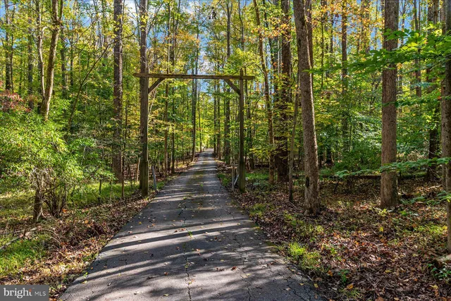 a front view of a house with a garden and trees
