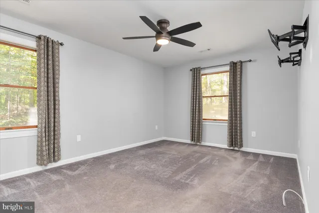 a bathroom with a granite countertop toilet sink mirror and vanity
