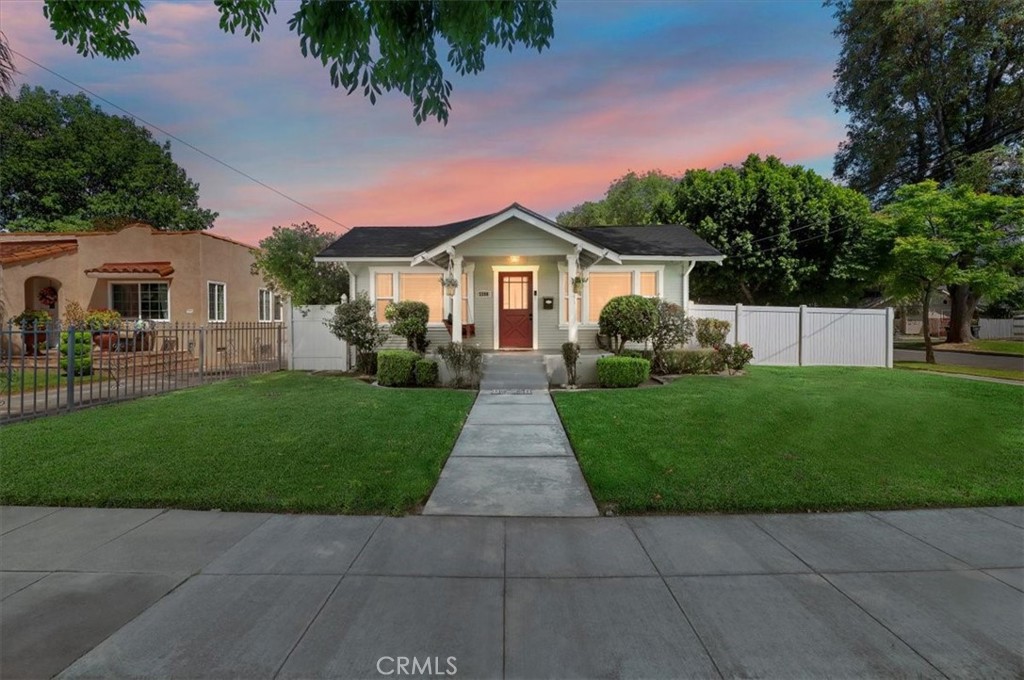 a front view of a house with a garden and trees