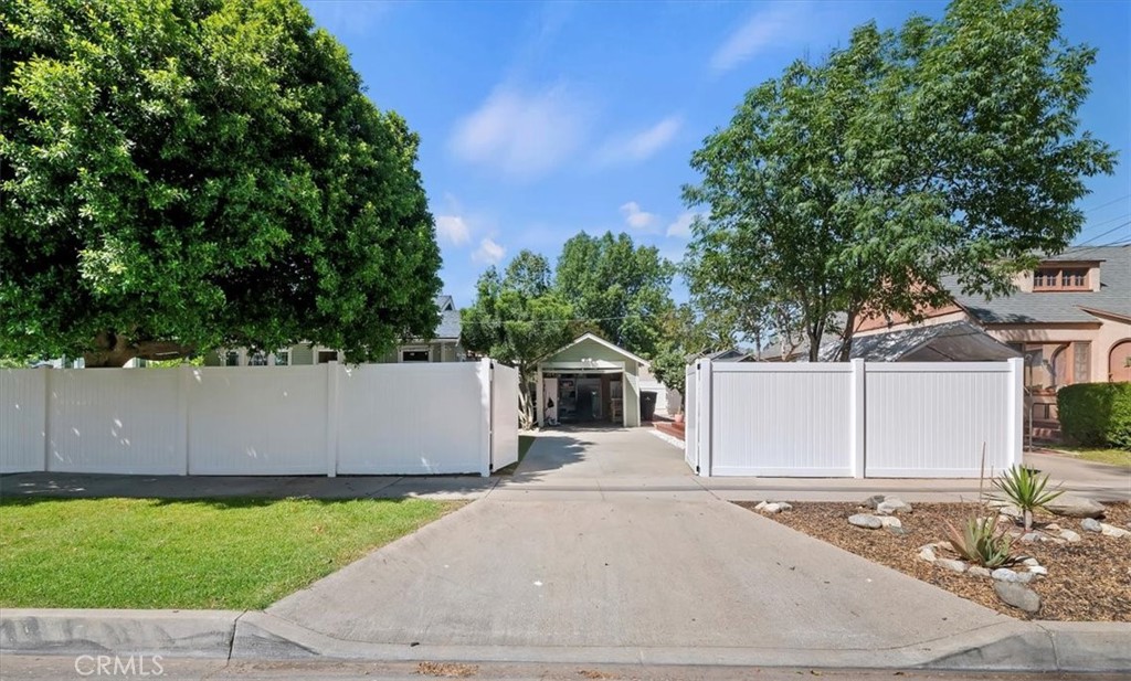 3398 Locust Street Riverside, CA 92501 - Photo 33 of 33 a view of a white house with a yard and a large tree