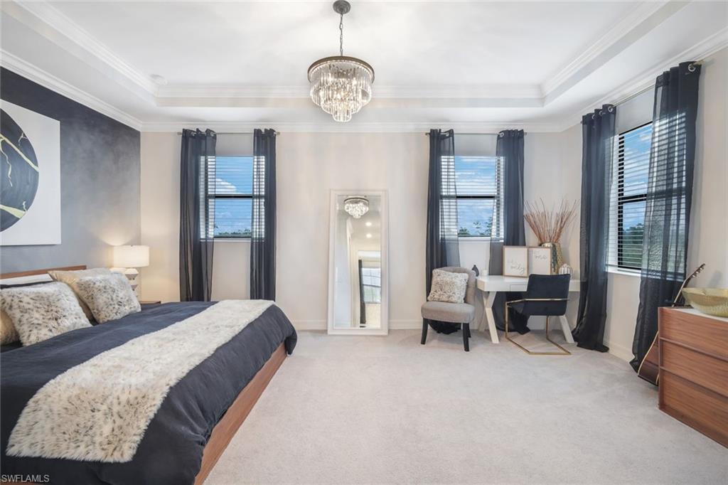 19477 The Pl Boulevard Estero, FL 33928 - Photo 15 of 36 a bedroom with a large bed and a chandelier