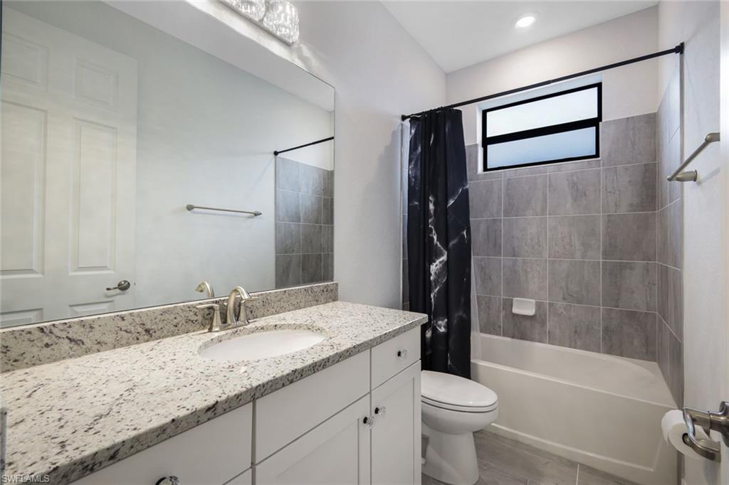 19477 The Pl Boulevard Estero, FL 33928 - Photo 18 of 36 a bathroom with a granite countertop sink toilet and shower