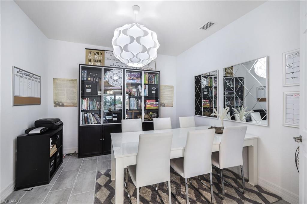 19477 The Pl Boulevard Estero, FL 33928 - Photo 21 of 36 a view of a dining room with furniture wooden floor and chandelier