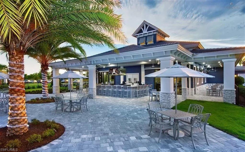 19477 The Pl Boulevard Estero, FL 33928 - Photo 31 of 36 a view of a patio with a table and chairs under an umbrella