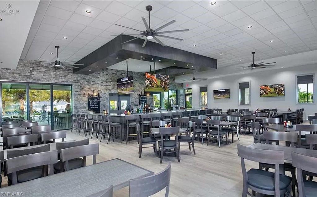 19477 The Pl Boulevard Estero, FL 33928 - Photo 33 of 36 a view of a big room with dining table chairs and chandelier