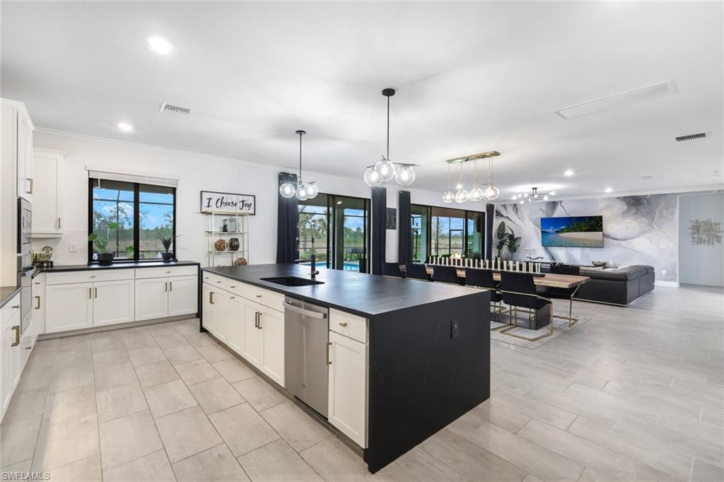 19477 The Pl Boulevard Estero, FL 33928 - Photo 5 of 36 a large kitchen with kitchen island a large counter top stainless steel appliances and cabinets