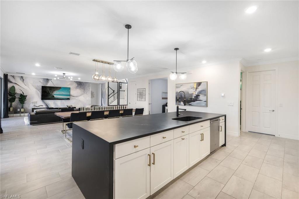19477 The Pl Boulevard Estero, FL 33928 - Photo 6 of 36 a kitchen with stainless steel appliances granite countertop a sink a counter space and a view of living room