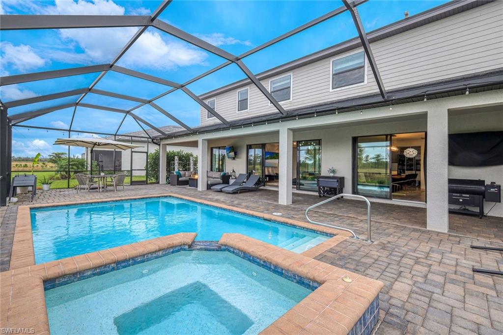 19477 The Pl Boulevard Estero, FL 33928 - Photo 10 of 36 a view of a patio with a table and chairs under an umbrella