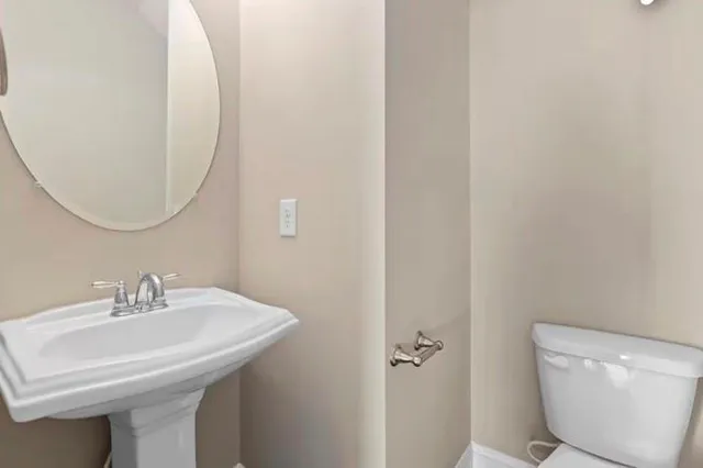 a bathroom with a sink toilet and a mirror