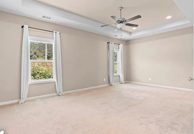 an empty room with a ceiling fan and window