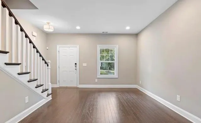 a view of an entryway with wooden floor and door