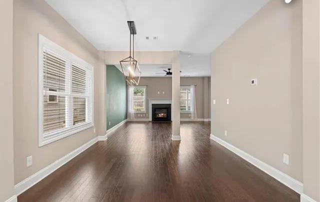 a view of a livingroom with wooden floor fireplace and window