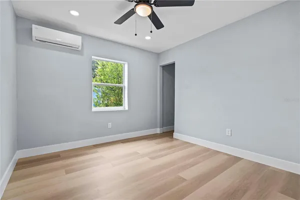 an empty room with a window and a ceiling fan