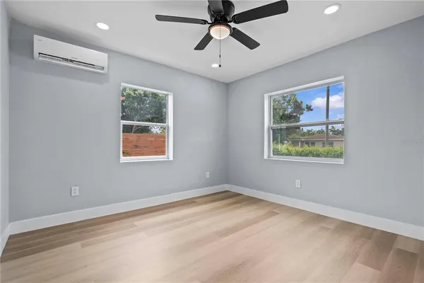 a view of empty room with window and ceiling fan