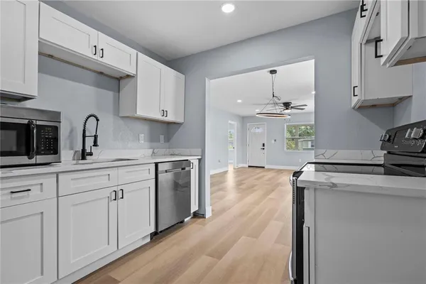 a kitchen with white cabinets and sink