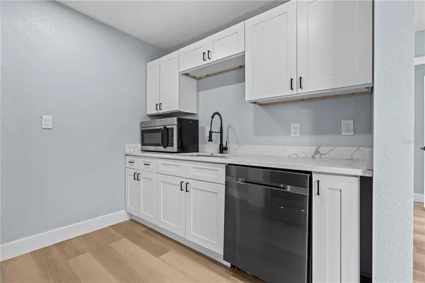 a kitchen with stainless steel appliances granite countertop a sink and a microwave